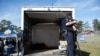 A police officer secures guns to be transported in the back of a truck during a gun buyback program in Houston, Texas, Feb. 18, 2023.