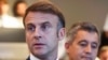 France's President Emmanuel Macron (L) gives a speech next to France's outgoing Minister for Interior and Overseas Gerald Darmanin (R) as they meet French police officers during the Paris 2024 Olympic Games in Paris, July 27, 2024.