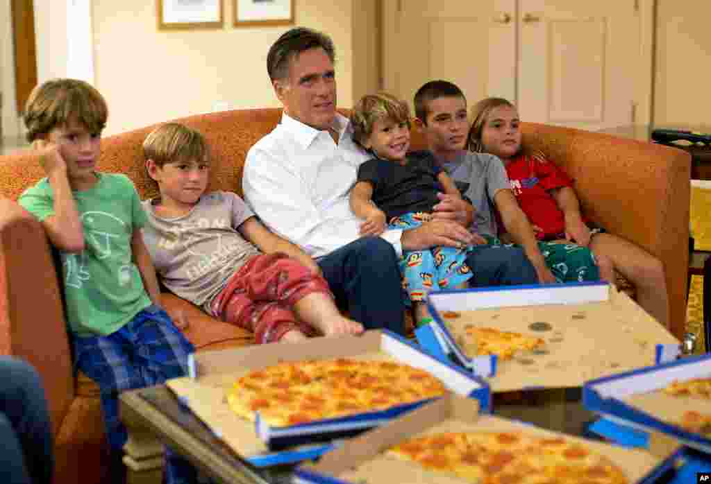 29/8/2012: Từ một phòng khách sạn ở Florida, ông Mitt Romney, ứng cử viên tổng thống của đảng Cộng hòa Mỹ cùng các cháu nội ngoại đang xem TV về đại hội toàn quốc của đảng. (AP Photo/Evan Vucci, File)