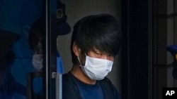 FILE - Tetsuya Yamagami, the alleged assassin of Japan's former Prime Minister Shinzo Abe, exits a police station in Nara, western Japan, on July 10, 2022, on his way to local prosecutors' office.