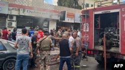 People and first responders gather at the scene of a reported device explosion in Saida in southern Lebanon on September 18, 2024.