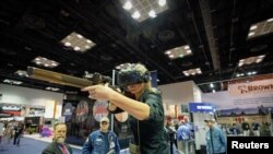 A woman uses a virtual reality based firearms simulator at the National Rifle Association's (NRA) annual meeting, in Indianapolis, Indiana, U.S., April 28, 2019. REUTERS/Bryan Woolston - RC1591E26900