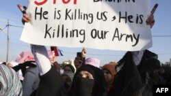 Syrian protester holds up a sign as she takes part in a protest calling for Syria's President Bashar al-Assad to step down, in front of the Syrian embassy in Amman, May 1, 2011