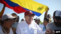 (FILES) The Venezuelan opposition presidential candidate for the Plataforma Unitaria Democratica party, Edmundo Gonzalez Urrutia (C), greets supporters upon his arrival at the campaign act in Barlovento Town in Miranda State, Venezuela, on June 26, 2024.